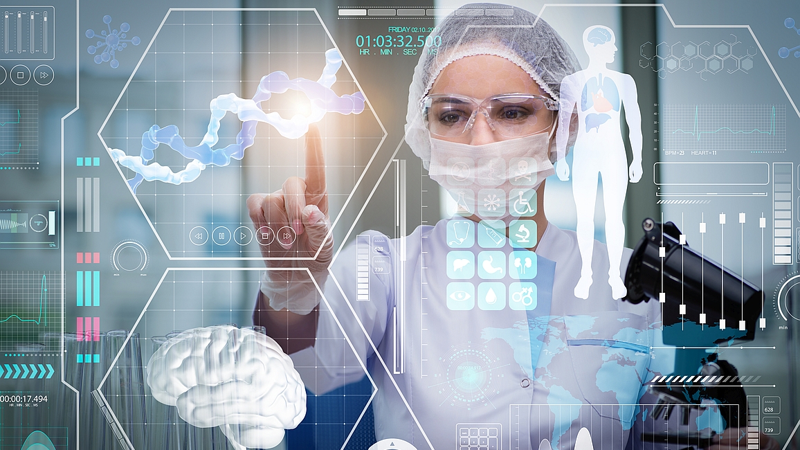 Frau in Laborkleidung tippt auf transparente Schautafel mit medizinischen Symbolen